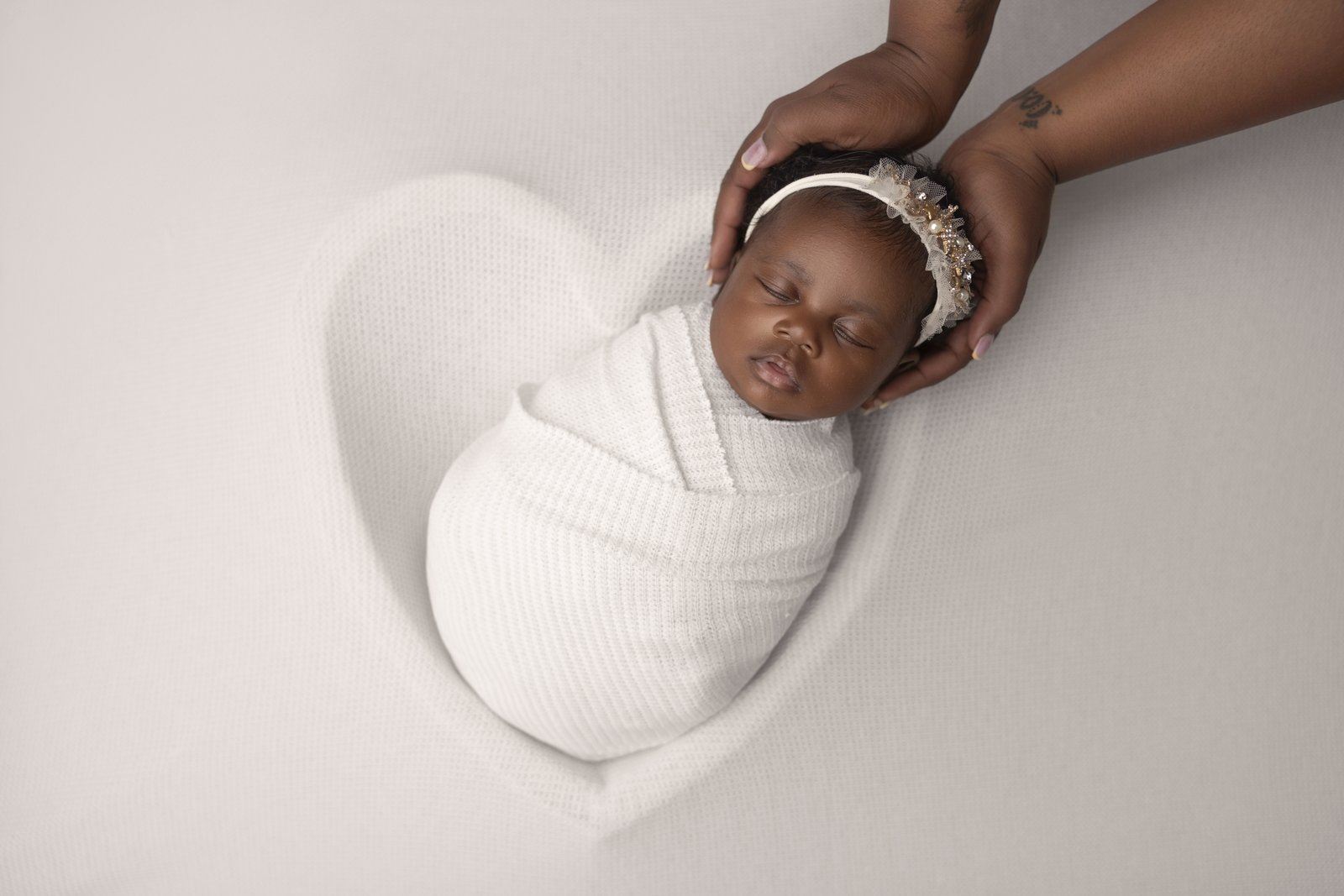 Newborn baby in a blue heart wrap at Chana Mirel Photography Baltimore studio